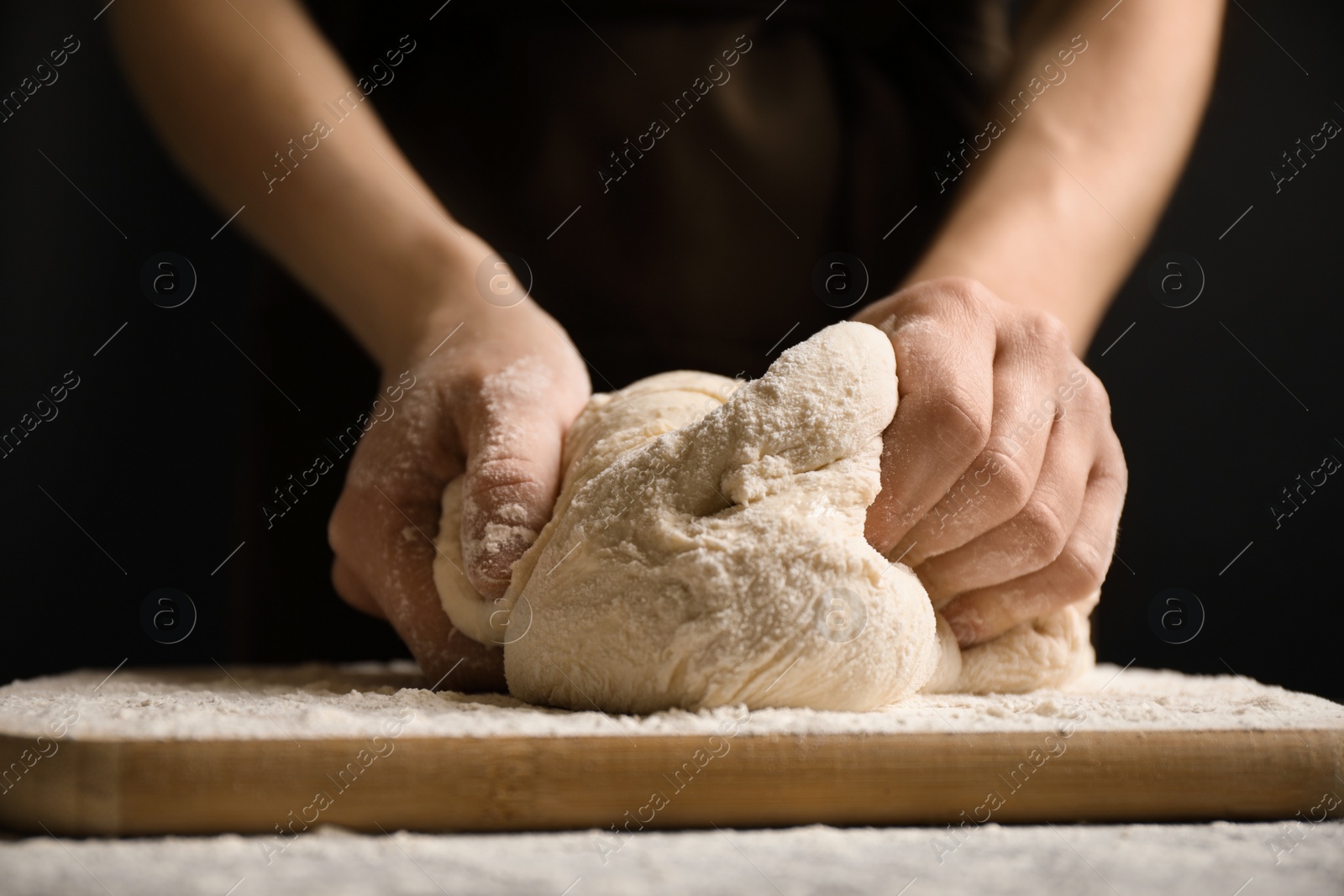 Photo of Woman beating dough at table, closeup. Making pasta