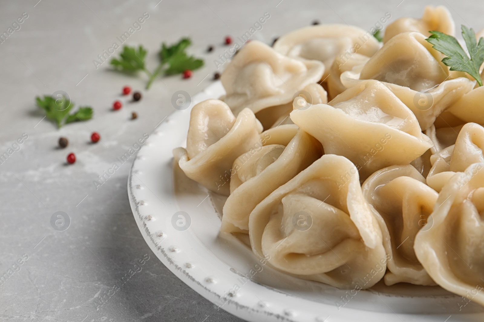 Photo of Tasty dumplings with parsley on plate, closeup view