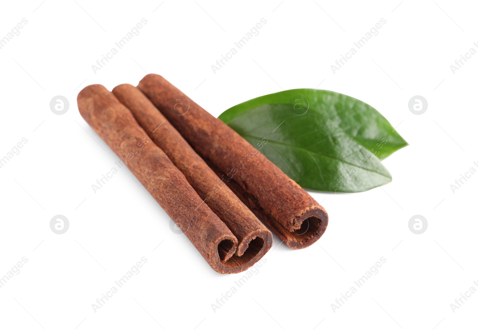 Photo of Cinnamon sticks and green leaves isolated on white