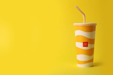 Photo of MYKOLAIV, UKRAINE - AUGUST 12, 2021: Cold McDonald's drink on yellow background. Space for text
