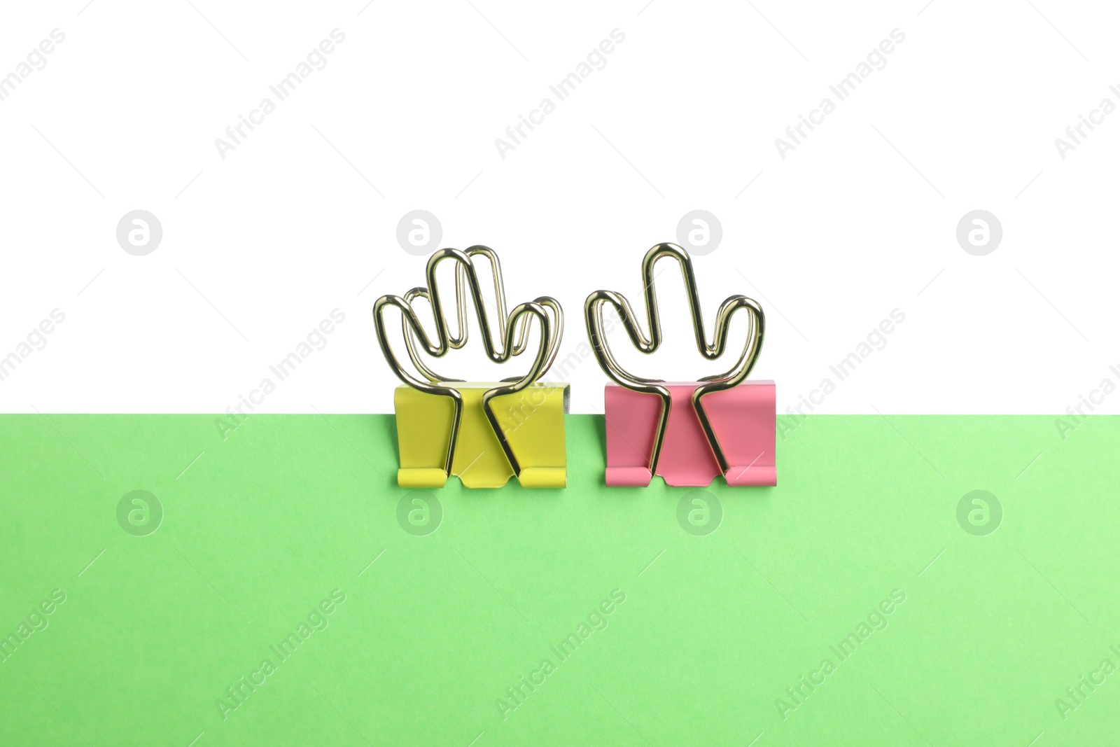Photo of Green paper with colorful binder clips isolated on white