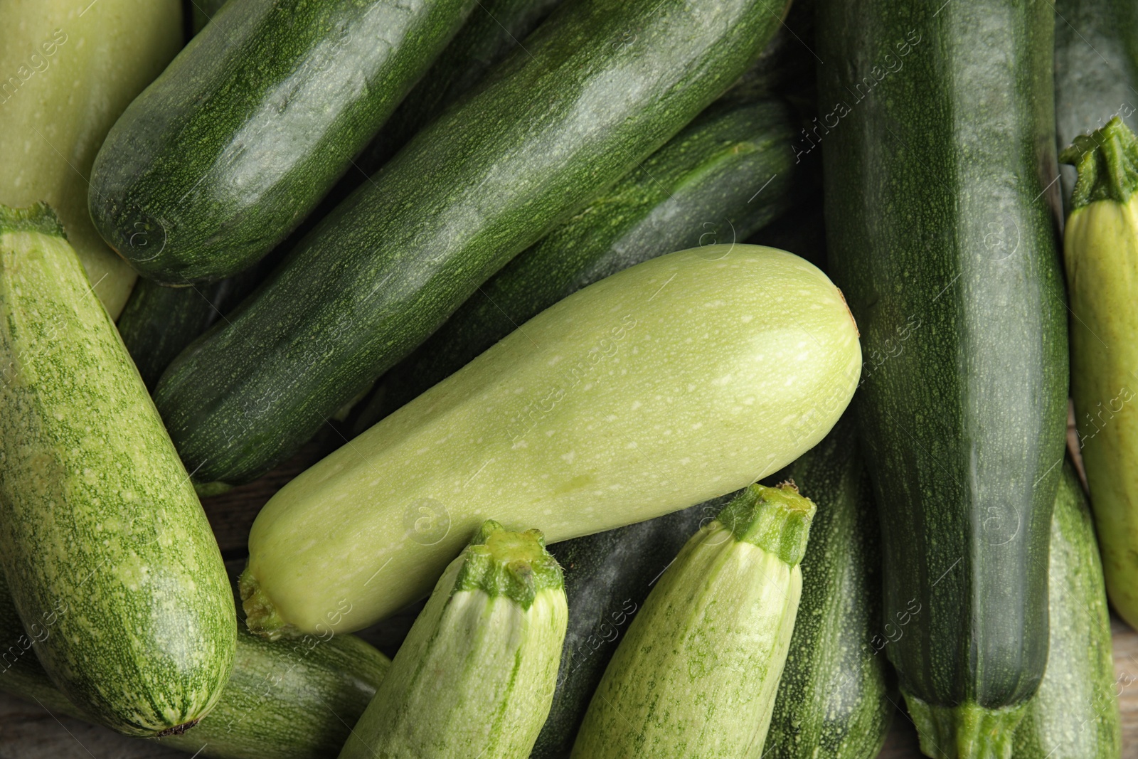 Photo of Top view of fresh ripe zucchini as background, closeup