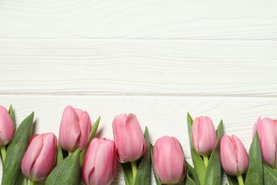 Happy Mother's Day. Beautiful pink tulips on white wooden table, flat lay. Space for text