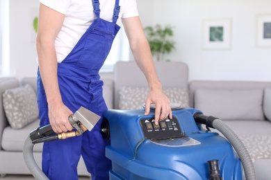 Photo of Dry cleaning worker with professional apparatus indoors