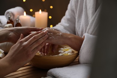 Woman receiving hand treatment at table in spa, closeup