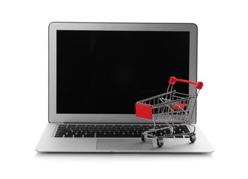 Internet shopping. Laptop with small cart isolated on white