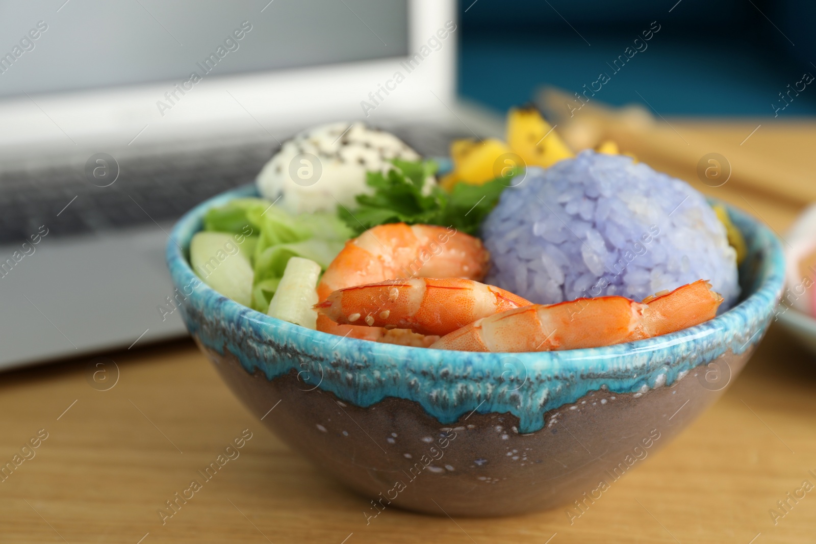 Photo of Delicious poke bowl served on wooden table, closeup