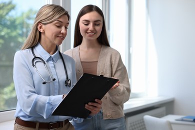 Photo of Professional doctor working with patient in hospital, space for text