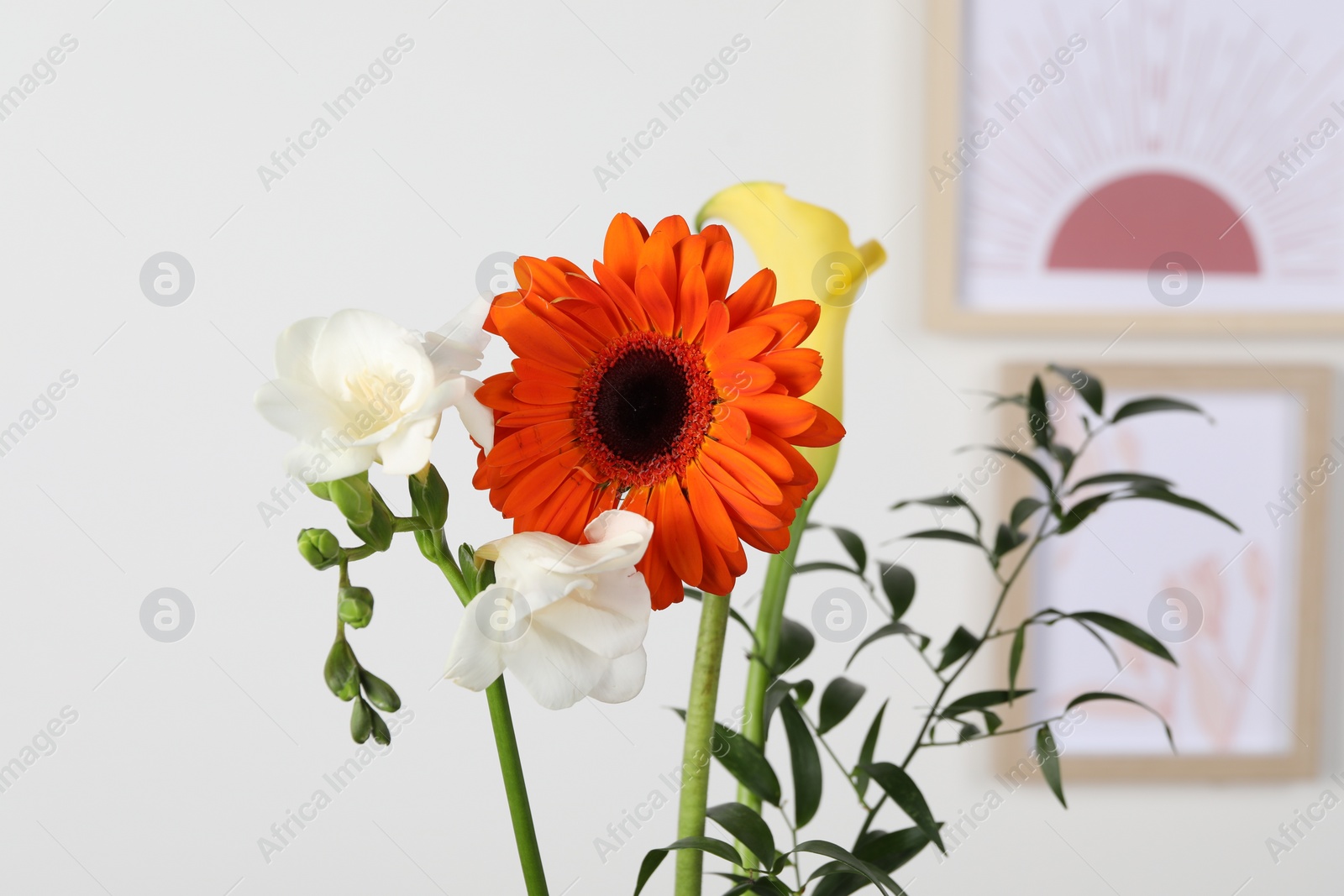 Photo of Stylish ikebana as house decor. Beautiful fresh flowers and branch on blurred background