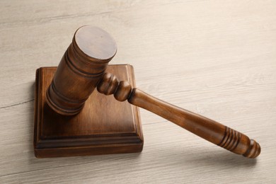 Photo of Wooden gavel and sound block on light table, closeup