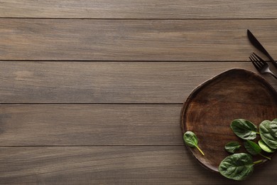 Photo of Food photography. Fresh basil, board and cutlery on wooden table, flat lay with space for text