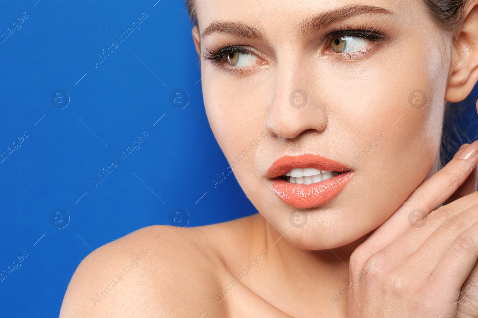 Photo of Young woman wearing beautiful lipstick on color background