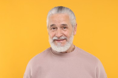 Photo of Portrait of handsome senior man on orange background