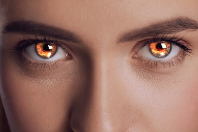 Image of Woman with fire burning in her eyes, closeup. Evil eye