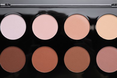 Photo of Colorful contouring palette as background, top view. Professional cosmetic product