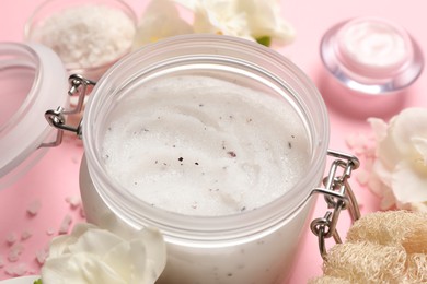 Photo of Body scrub in glass jar on pink background, closeup