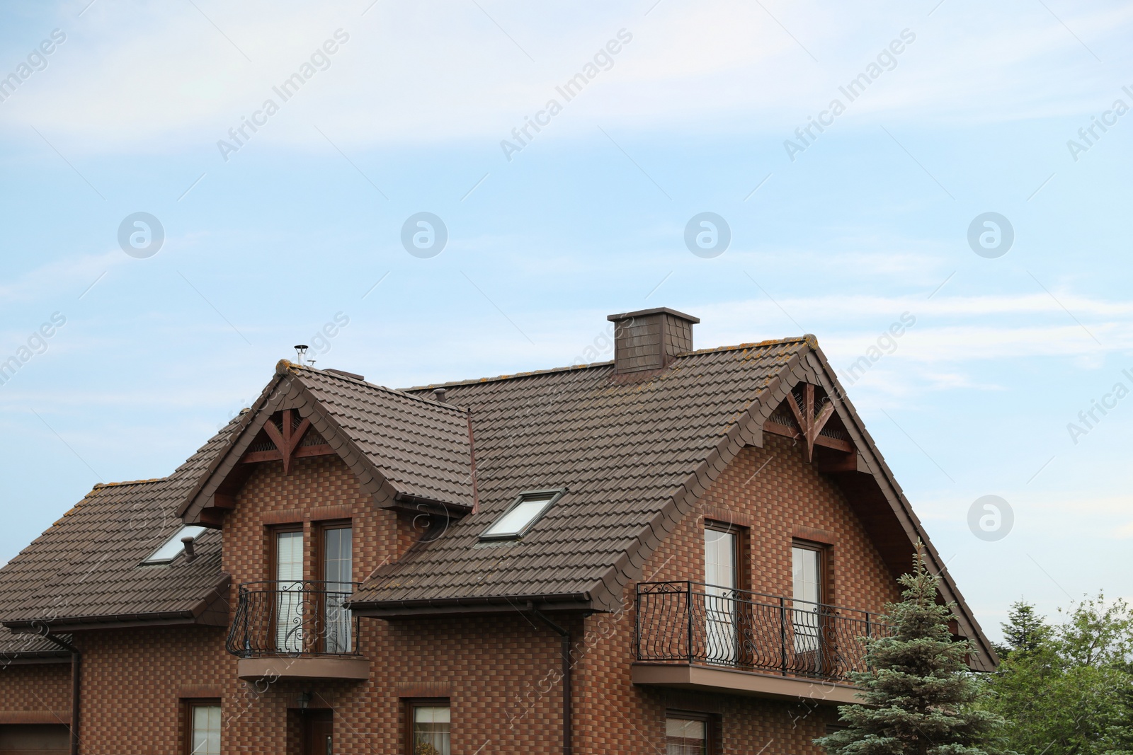 Photo of Beautiful house with brown roof against blue sky