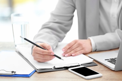 Consultant working at table in office, closeup