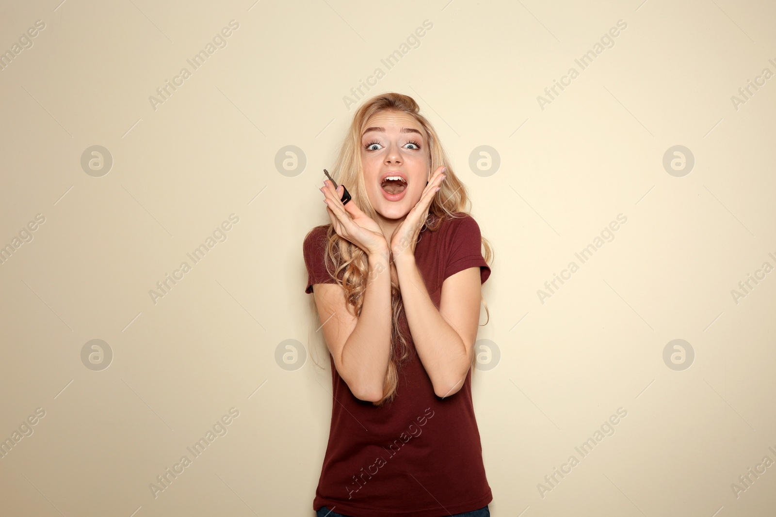 Photo of Happy young woman with car key on color background. Getting driving license