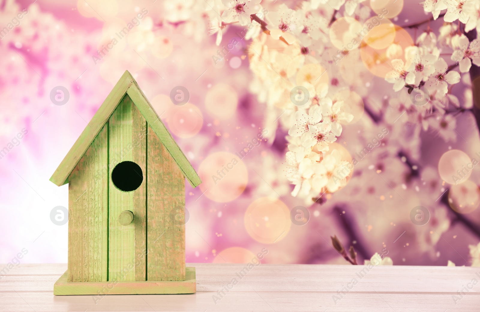 Image of Beautiful bird house on wooden table outdoors, space for text
