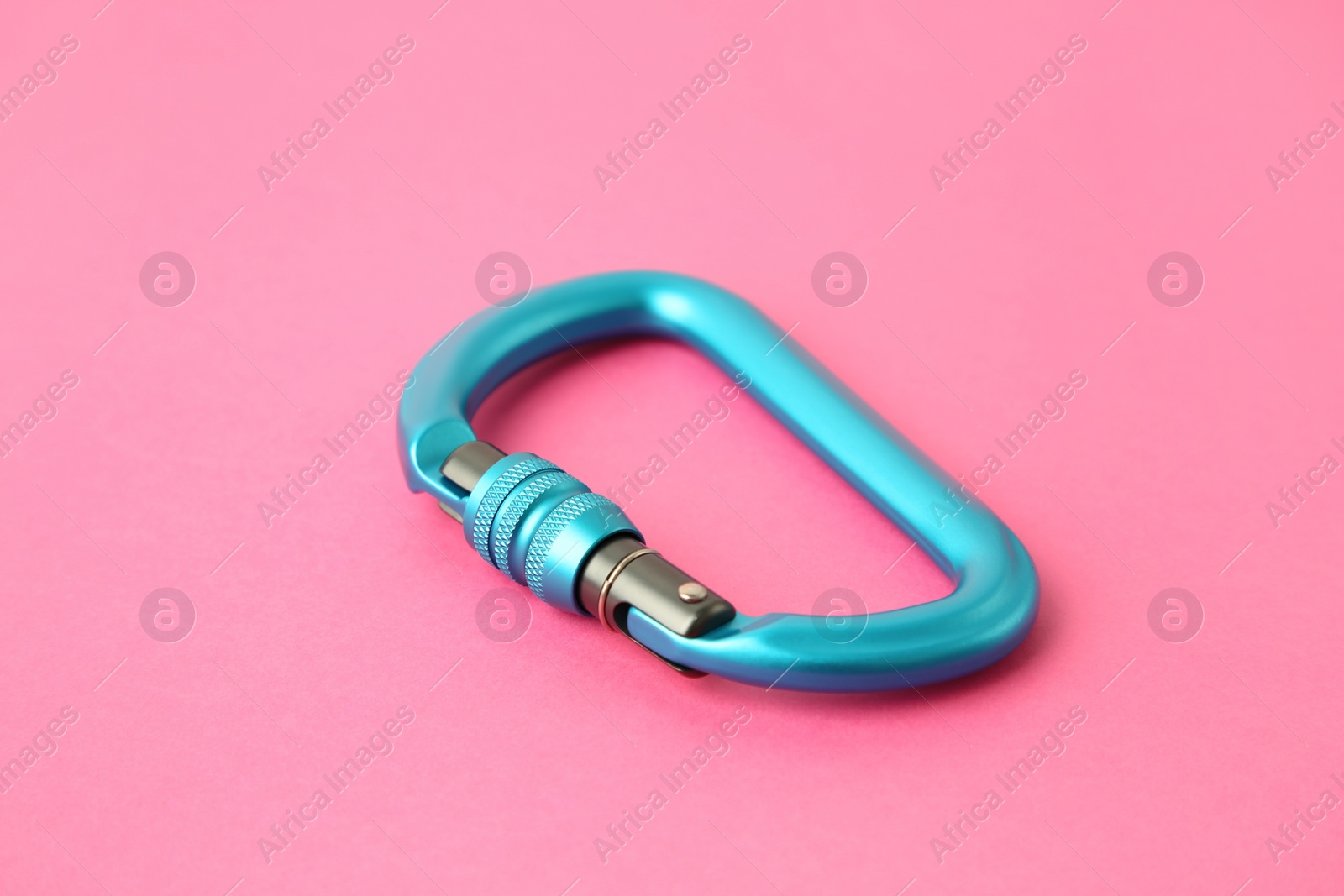 Photo of One metal carabiner on bright pink background