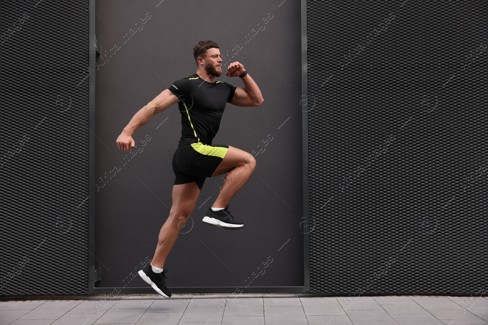 Photo of Young man running near building outdoors. Space for text