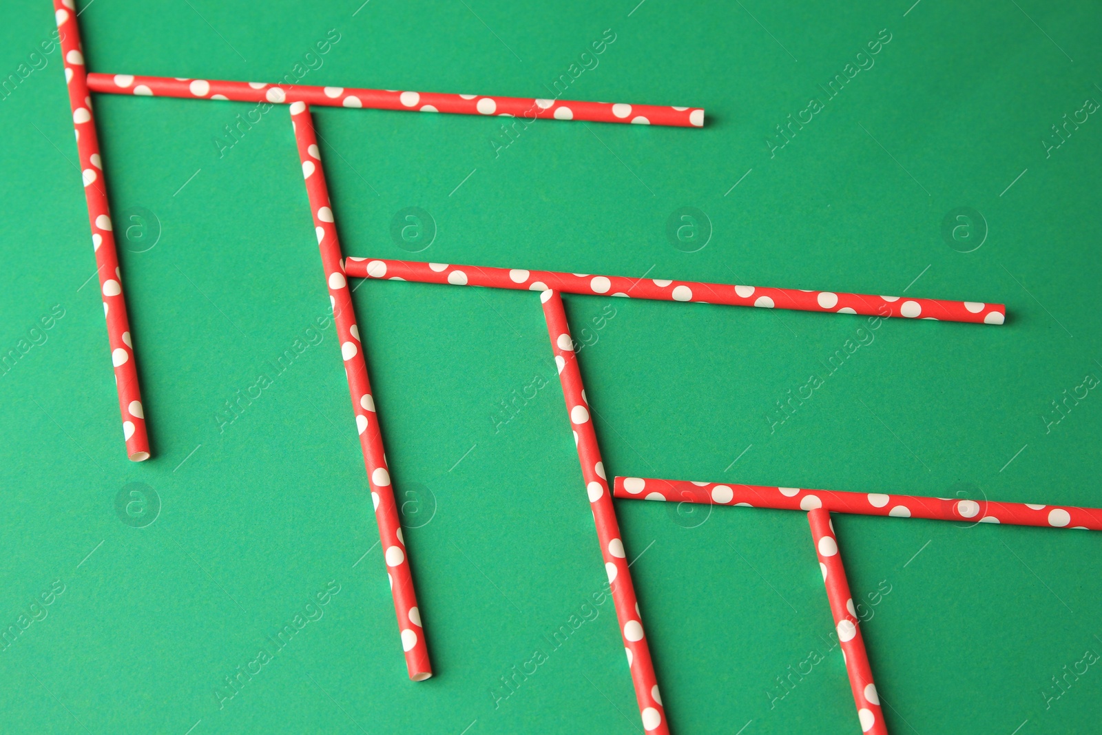 Photo of Many paper drinking straws on green background