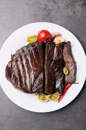 Photo of Delicious grilled beef meat on grey table, top view