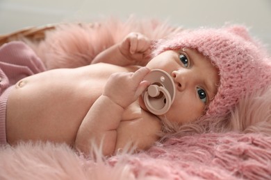 Adorable newborn baby with pacifier in wicker basket