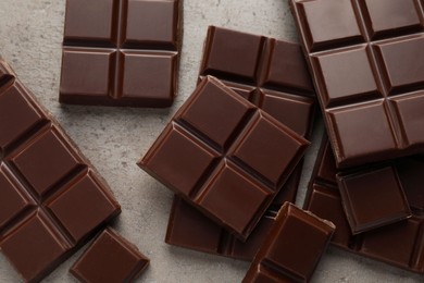 Delicious dark chocolate on grey table, flat lay