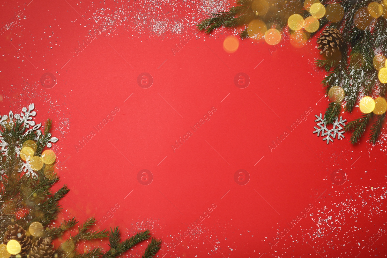 Photo of Christmas greeting card with space for text. Flat lay composition of fir tree branches and festive decor on red background