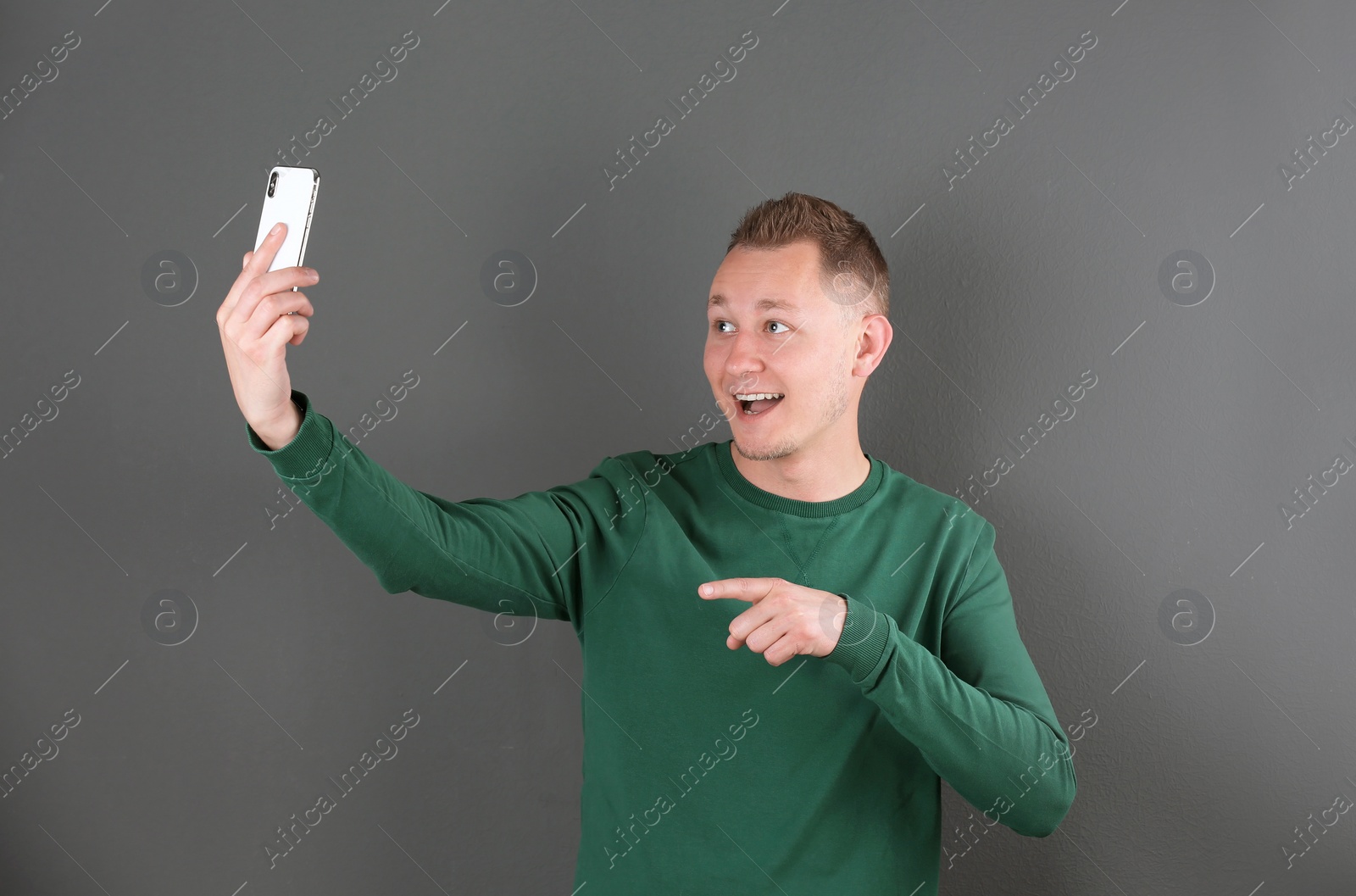 Photo of Handsome man taking selfie on color background