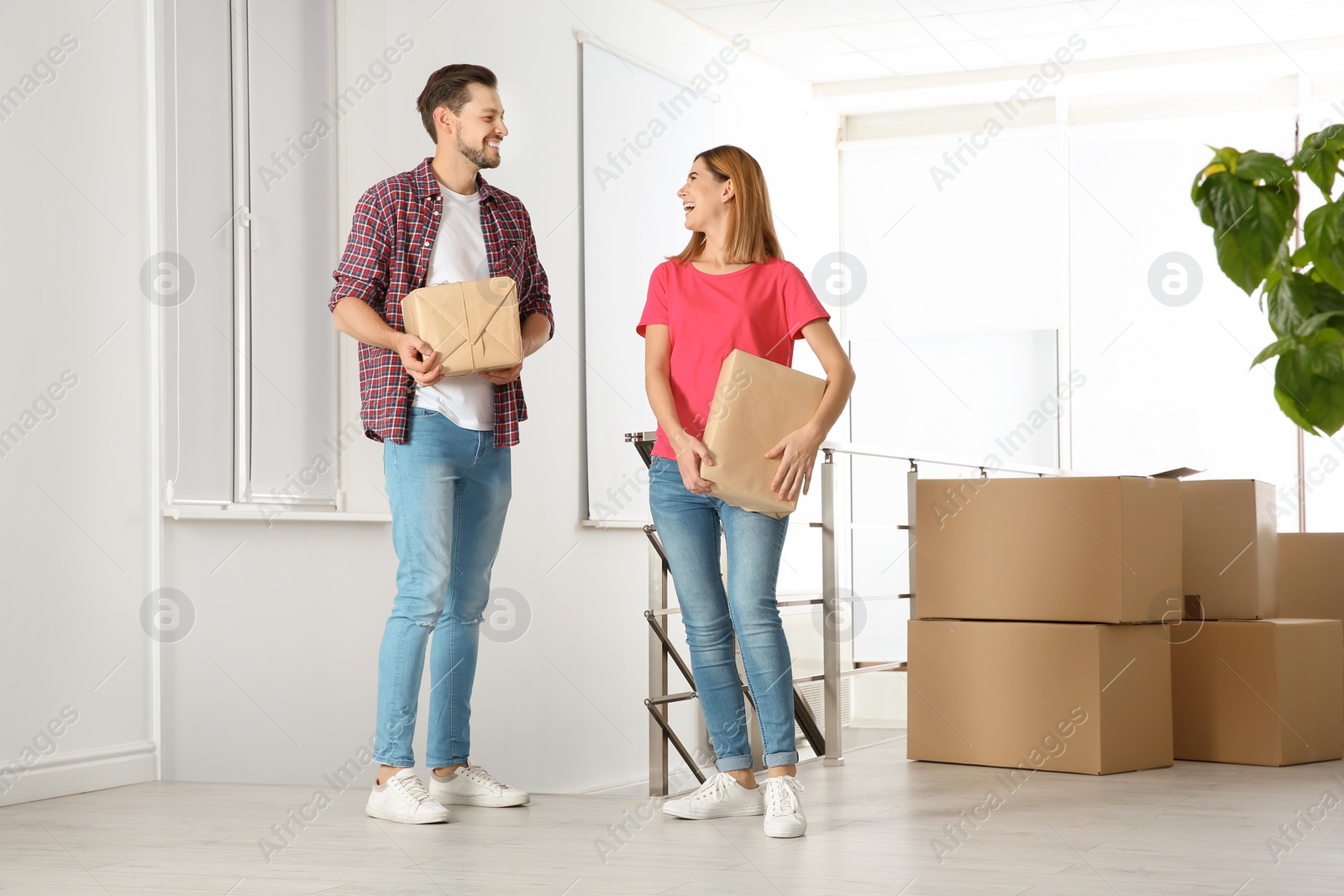 Photo of Couple with moving boxes in their new house