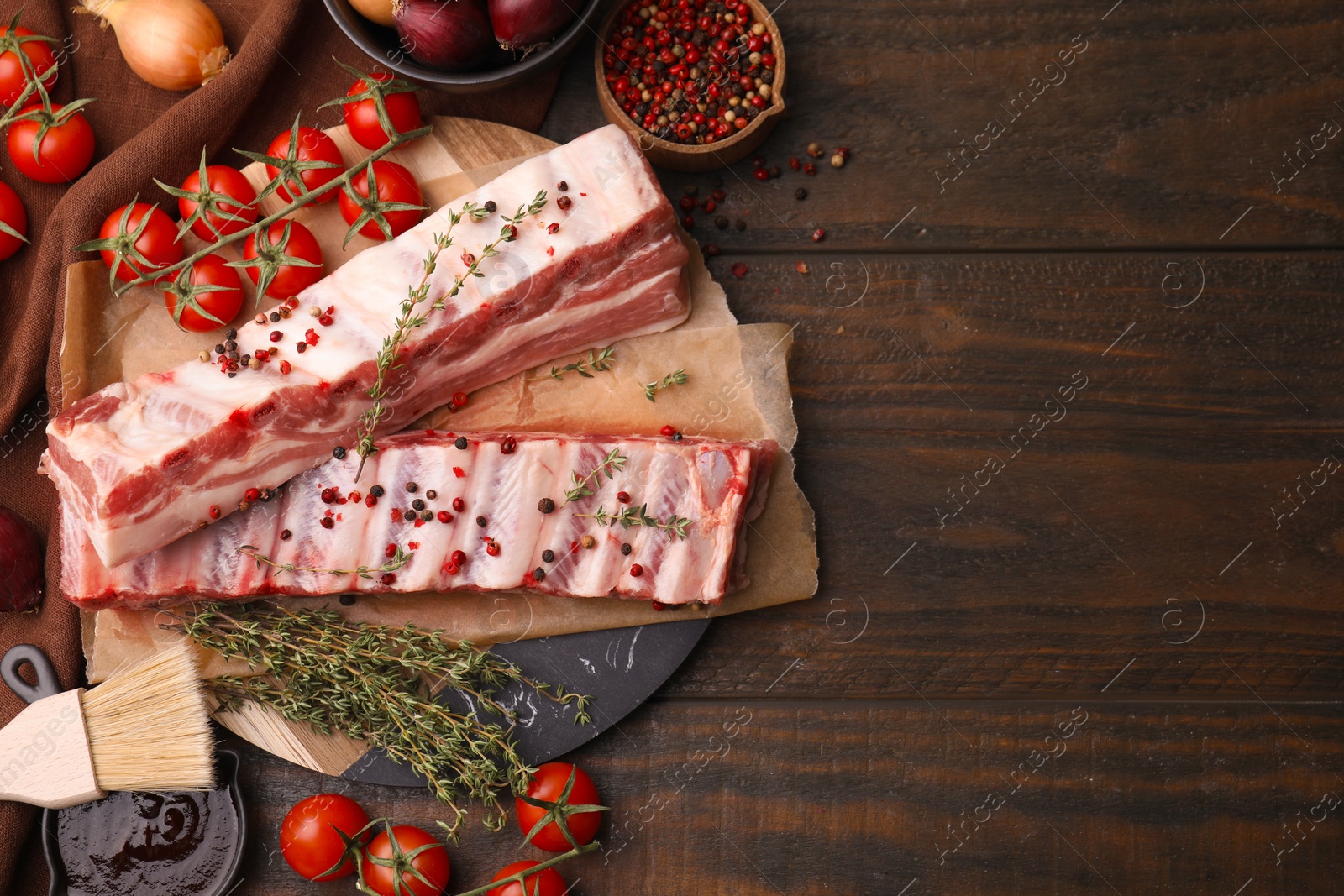 Photo of Flat lay composition with raw pork ribs and sauce on wooden table. Space for text