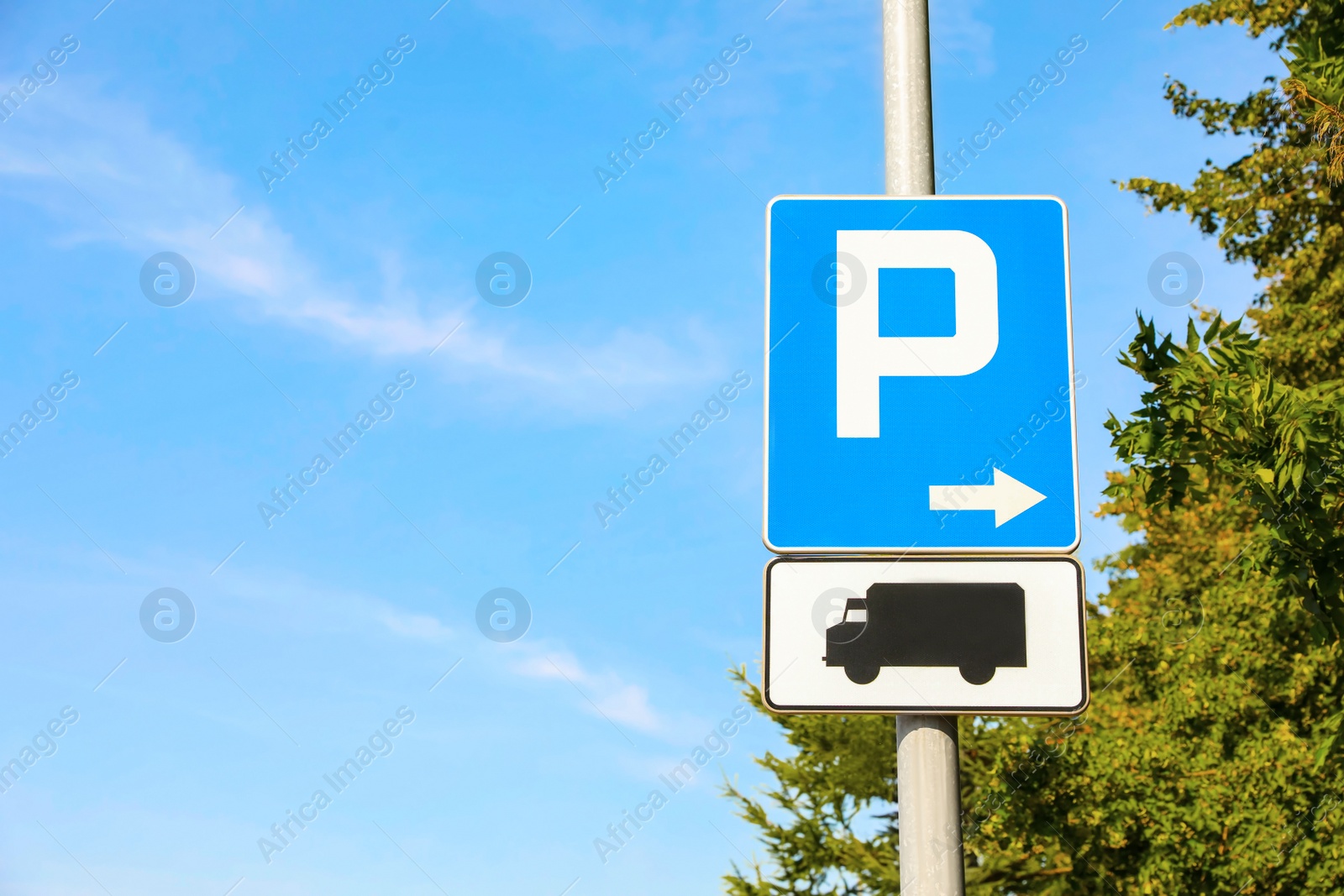 Photo of Post with different road signs Parking Right and Plate Indicating Trucks outdoors on sunny day. Space for text