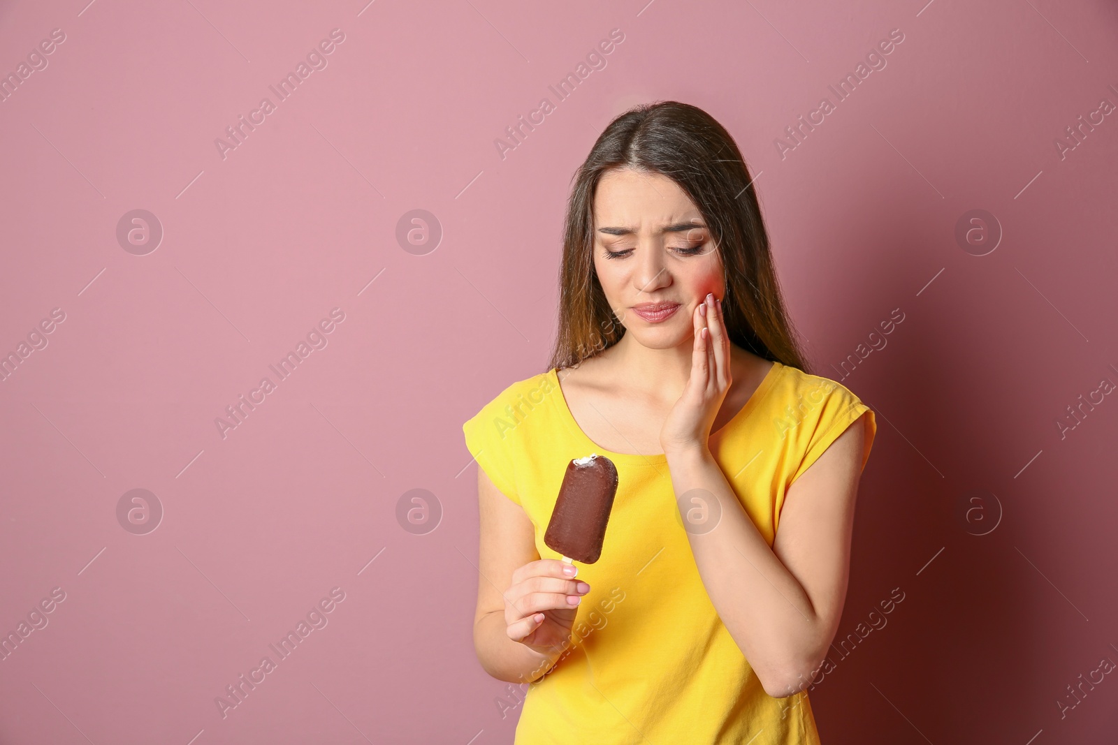 Photo of Woman with sensitive teeth holding ice cream on color background