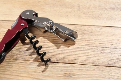 Photo of One corkscrew (sommelier knife) on wooden table. Space for text