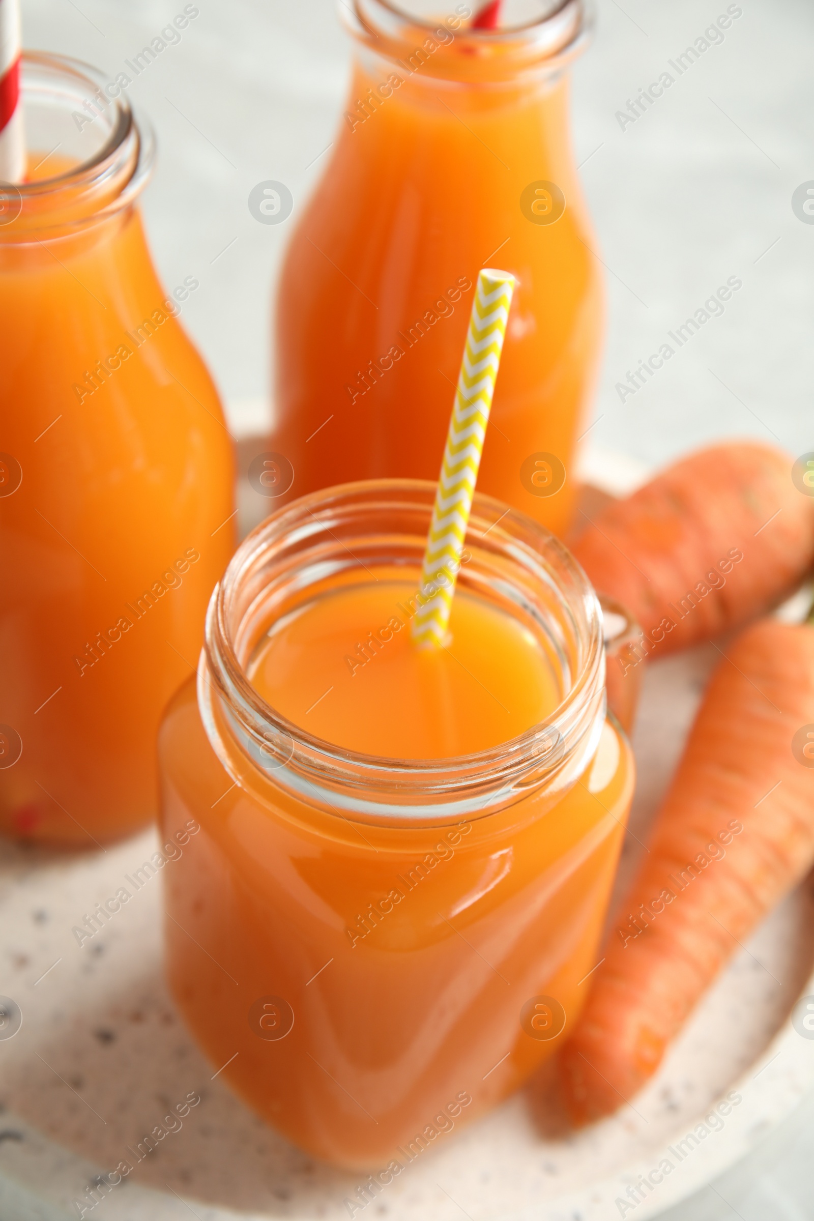 Photo of Freshly made carrot juice on table, closeup