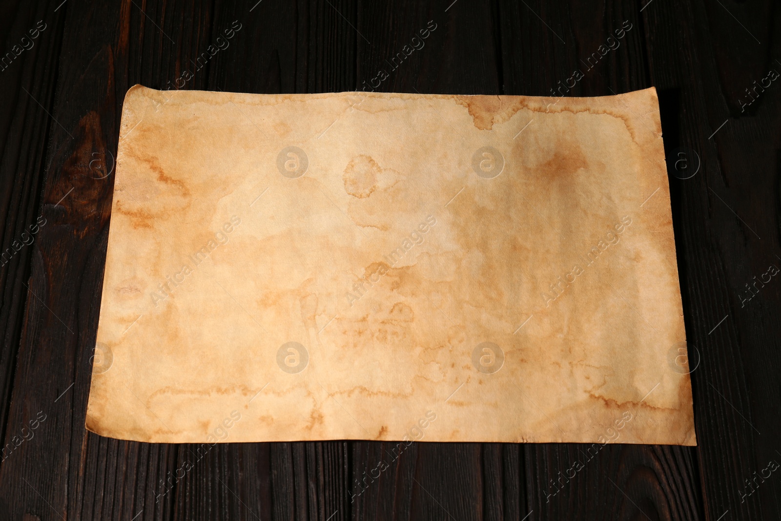 Photo of Sheet of old parchment paper on wooden table, above view