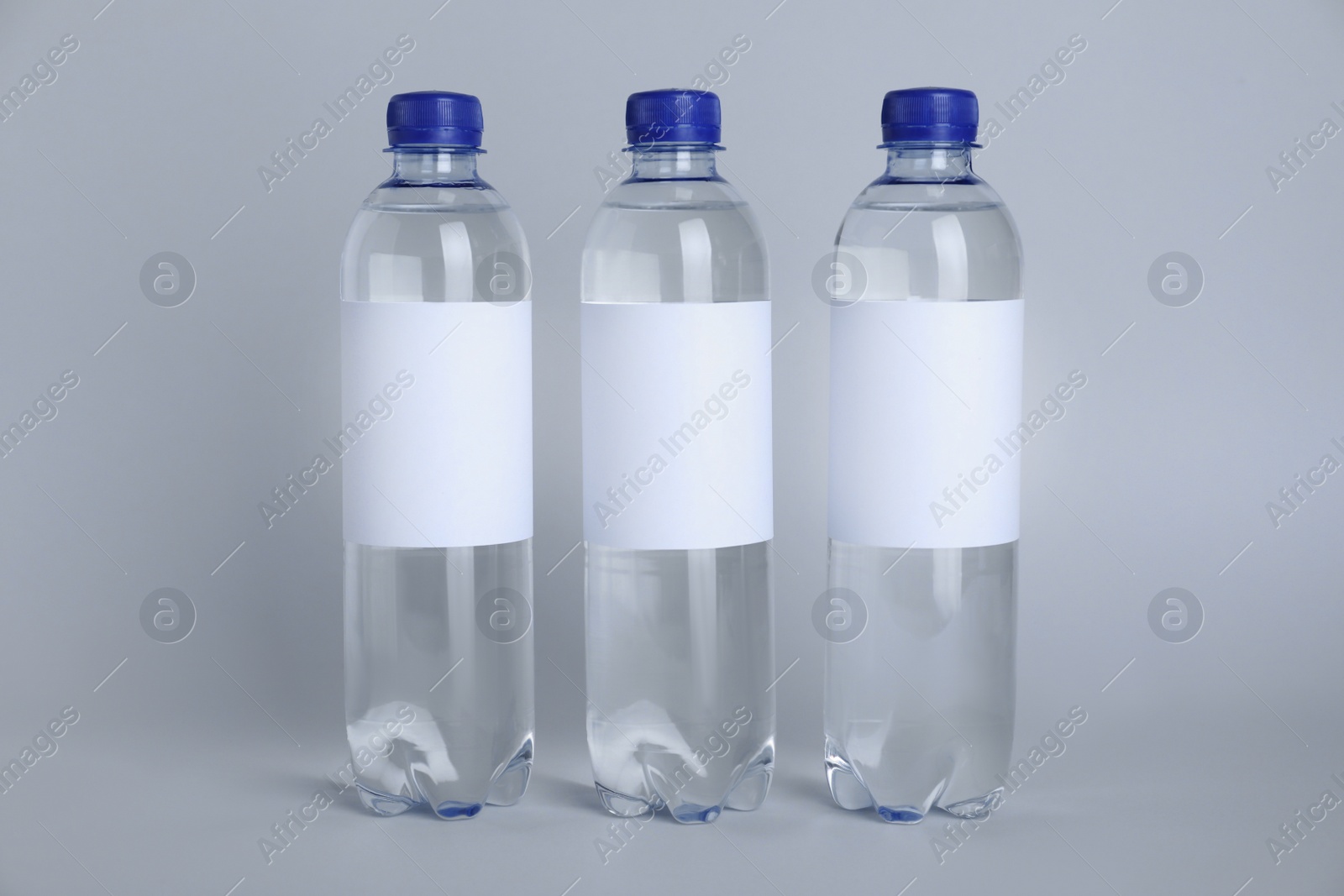Photo of Plastic bottles with soda water on light background