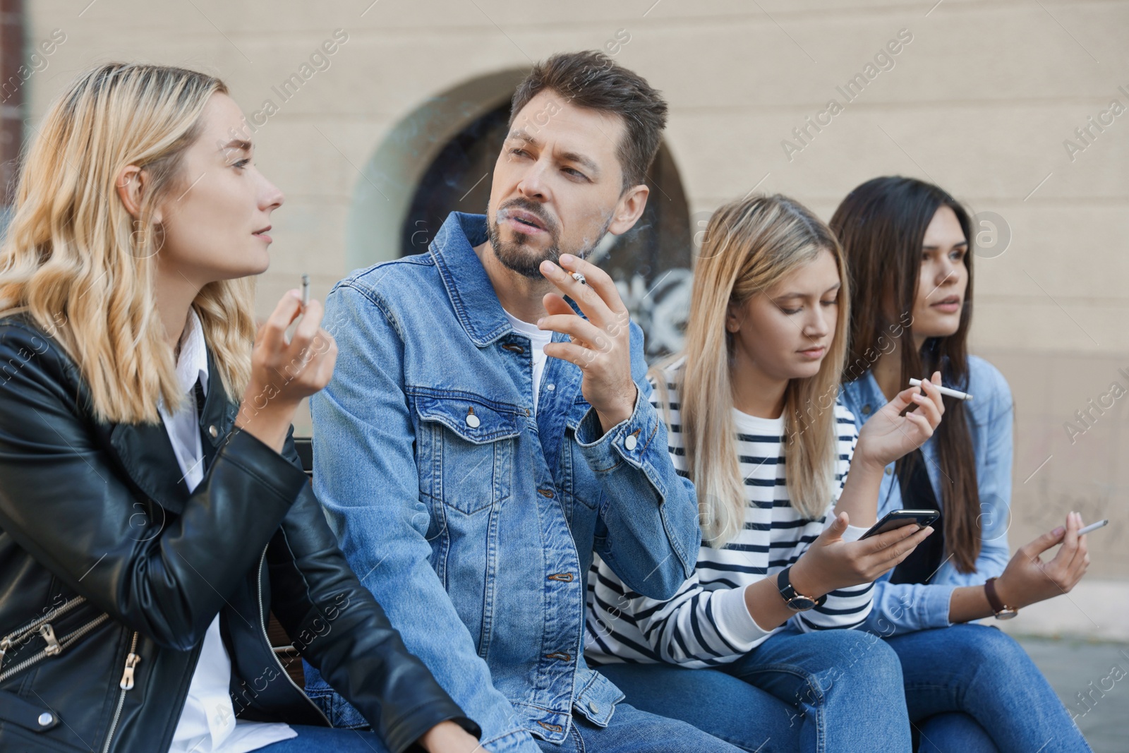 Photo of People smoking cigarettes at public place outdoors