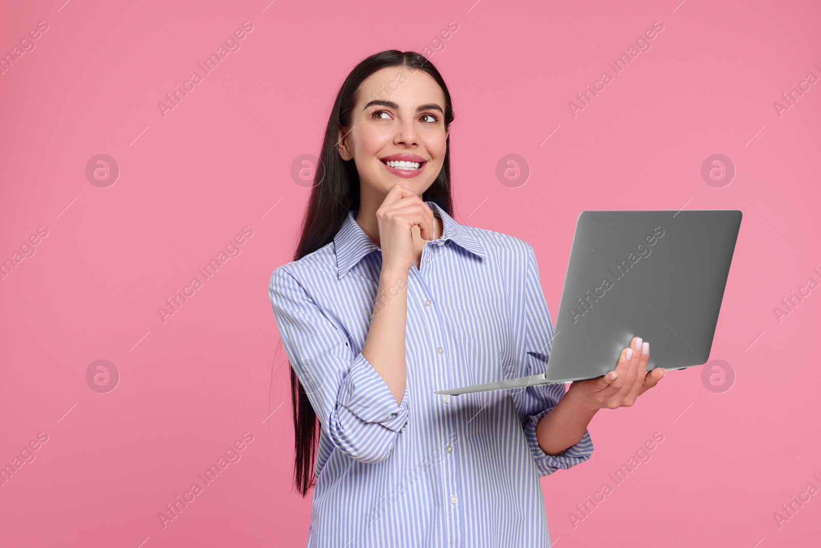 Photo of Happy woman with laptop on pink background