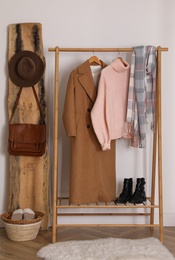 Stylish warm clothes on rack in dressing room interior