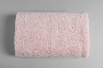 Photo of Soft folded towel on light background, top view