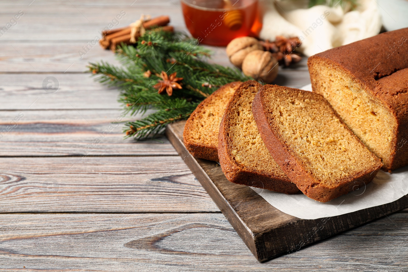 Photo of Fresh sliced gingerbread cake on wooden table, space for text