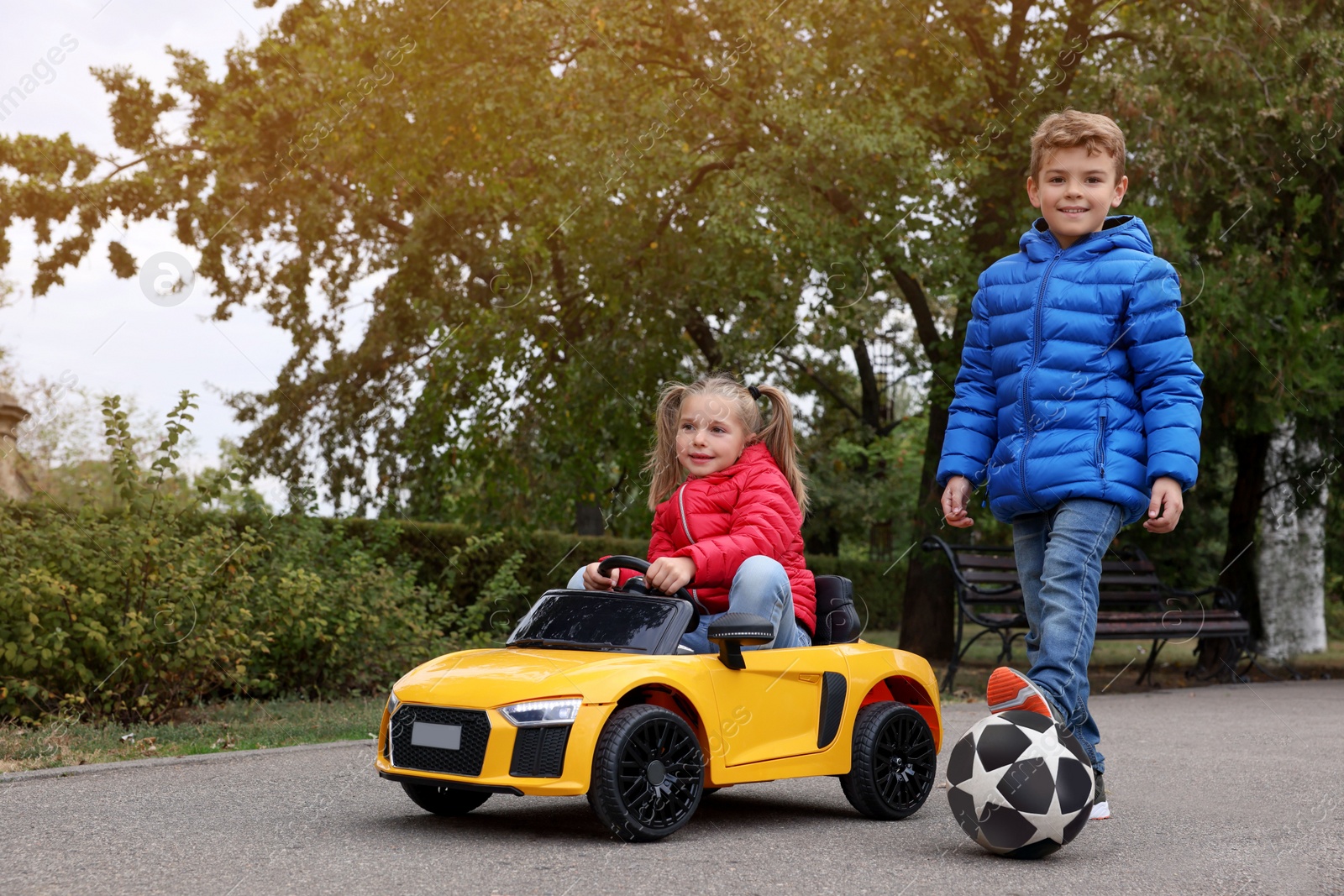 Photo of Cute little children with toy car and soccer ball having fun outdoors. Space for text