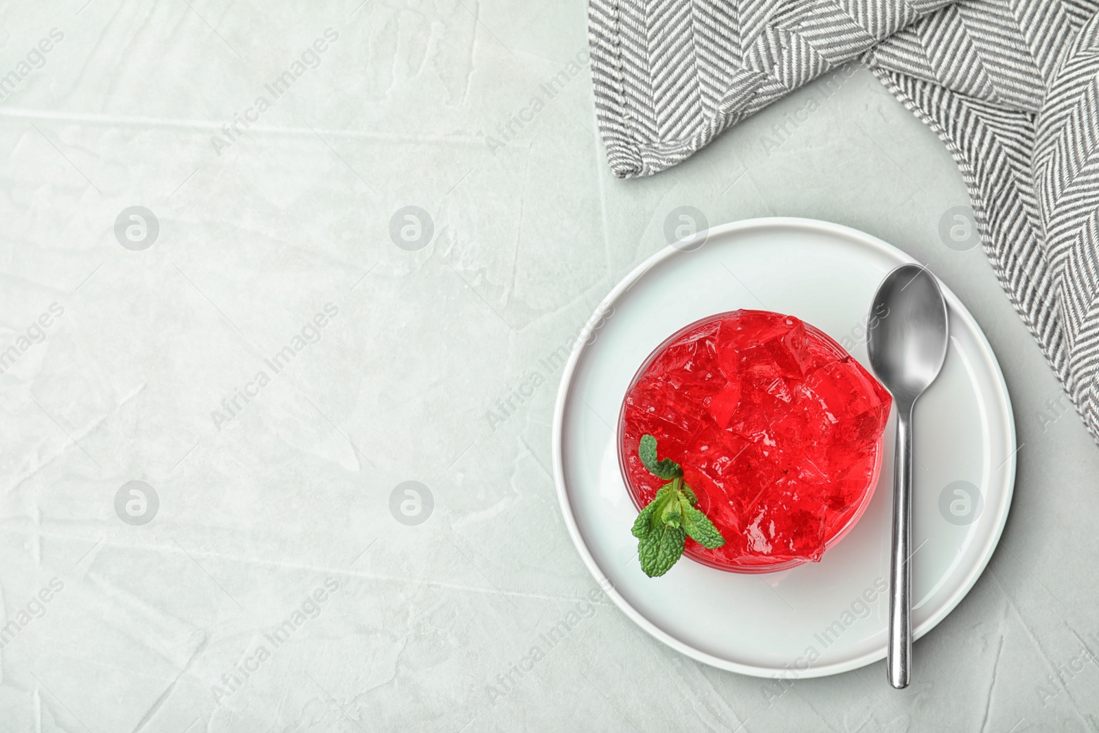 Photo of Flat lay composition with red jelly in bowl on light table. Space for text