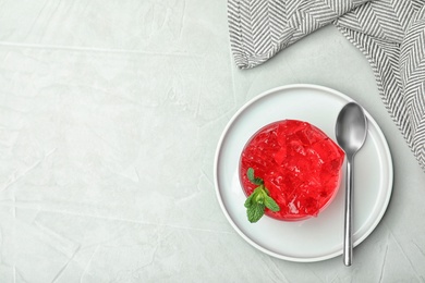 Flat lay composition with red jelly in bowl on light table. Space for text