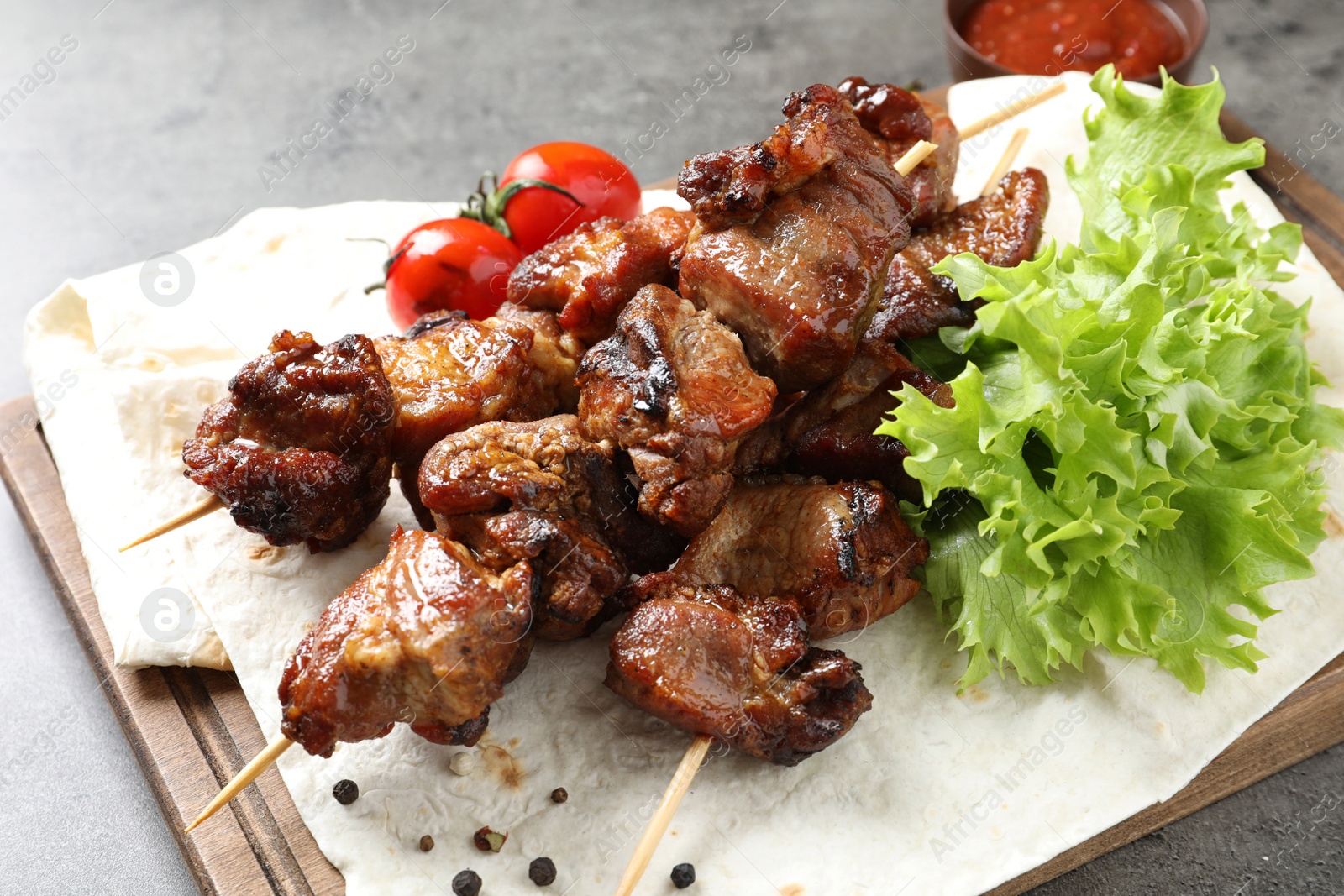 Photo of Delicious meat served for barbecue party on gray table