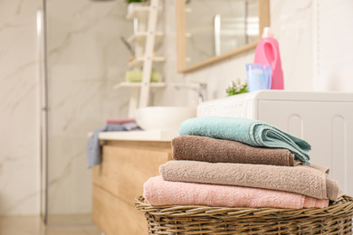 Wicker basket with laundry in bathroom, closeup. Space for text